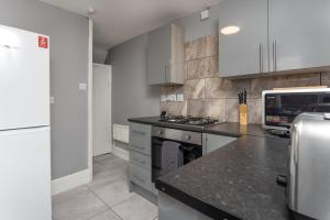 a kitchen with white cabinets and a stove top oven at Air Host & Stay - Newcombe House, 3 bedroom free parking in Liverpool