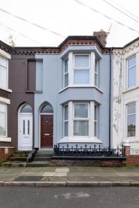 a blue house with a red door on a street at Air Host & Stay - Newcombe House, 3 bedroom free parking in Liverpool