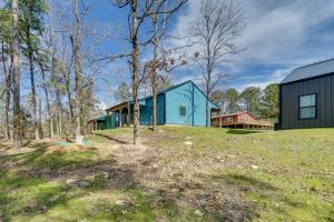 Broken Bow Cabin about 5 Mi to Beavers Bend State Park في بروكن بو: بيت ازرق وسط ميدان