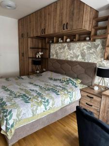 ein Schlafzimmer mit einem großen Bett und einer Holzwand in der Unterkunft Kraljevački Lux parking GARAŽA in Kraljevo