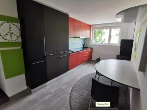 a kitchen with red and green cabinets and a table at Komfortables Zimmer in ruhiger Wohnlage, inkl. Tax in Dornbirn