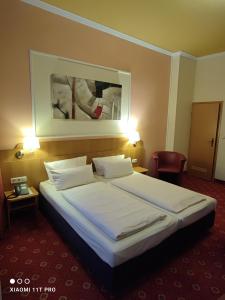 ein Schlafzimmer mit einem großen Bett in einem Hotelzimmer in der Unterkunft Hotel Königshof in Mainz