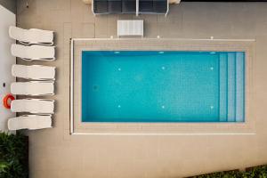 einem Pool an der Seite eines Gebäudes in der Unterkunft Periyiali Konnos Villas Beach Resort in Protaras