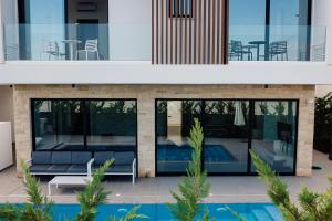 a house with a swimming pool in front of it at Periyiali Konnos Villas Beach Resort in Protaras