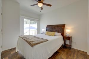 a white bedroom with a bed and a ceiling fan at Oak View Home with Private Covered Patio! in Oak View