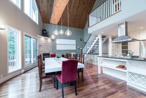 a kitchen and dining room with a table and chairs at Le Fitchbay in Magog-Orford