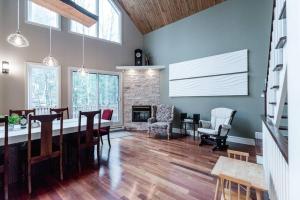 a dining room with a table and chairs and a fireplace at Le Fitchbay in Magog-Orford