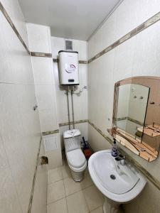 a bathroom with a toilet and a sink at Poytakht 80 Apartments in Dushanbe