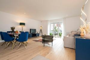 Belgravia Residence في لندن: غرفة معيشة مع طاولة وكراسي زرقاء