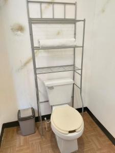 ein Badezimmer mit einem WC und einem Regal mit Handtüchern in der Unterkunft Hotel Sexta Avenida in Tapachula