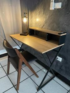 escritorio de madera con silla y lámpara en Hotel Sexta Avenida, en Tapachula