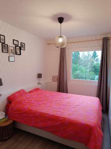 ein Schlafzimmer mit einem roten Bett und einem Fenster in der Unterkunft Appartement familial in Vélizy-Villacoublay