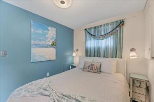 a blue bedroom with a bed and a window at Beach Cottage with heated pool just off Siesta Key in Sarasota