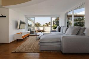 uma sala de estar com um sofá cinzento e uma televisão em Stunning penthouse with terrace in Condesa em Cidade do México