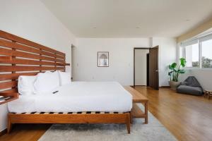 um quarto com uma grande cama branca e uma cabeceira em madeira em Stunning penthouse with terrace in Condesa em Cidade do México