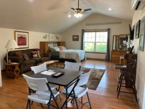 Una sala de estar con una mesa y sillas y una cama. en Majestic Retreat Studio, en Sturgis 22 fotos más