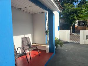 une paire de chaises assises sur la terrasse couverte d'une maison dans l'établissement Casa Beppe, à Águas de Santa Barbara