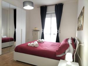 sypialnia z czerwonym łóżkiem i ręcznikami w obiekcie Borgo 90 Bergamo house w Bergamo