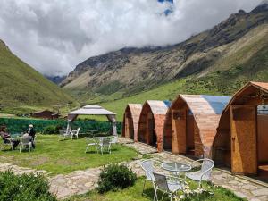 a group of tables and chairs in front of some huts at Soraypampa Hostel - Private Cabins & Dorms for Self-Guided Humantay & Salkantay Trek -Comidas-hot shower-wifi-Pack horses in Salcantay