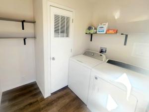 a white laundry room with a washer and dryer at The perfect get away home in Garden City +19 photos