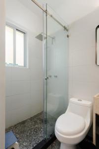 een badkamer met een toilet en een glazen douche bij Lovely 3BR in Roma Norte in Mexico-Stad
