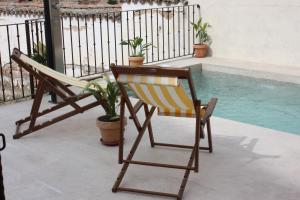 a chair and a table next to a swimming pool at Casa de Vivar a 5 minutos de Puy du Fou in Toledo