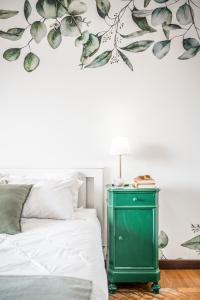 1 dormitorio con mesita de noche verde junto a la cama en CASA EMILIA - * In the HEART of MODENA * en Modena