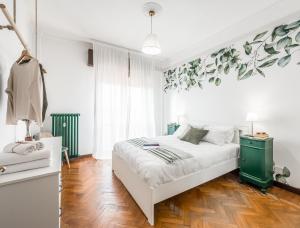 1 dormitorio con cama blanca y armario verde en CASA EMILIA - * In the HEART of MODENA * en Modena