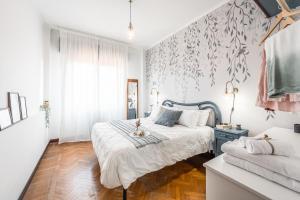 a white bedroom with a bed and a couch at CASA EMILIA - * In the HEART of MODENA * in Modena