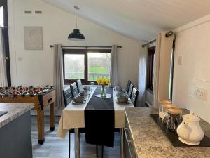 a dining room with a table and a chess board at Cosy 3 Bed Lodge in Hoburne, Cotswolds in South Cerney