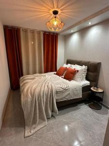 a bedroom with a bed with orange pillows on it at T3 5 étoile jacuzzi in Toulouse
