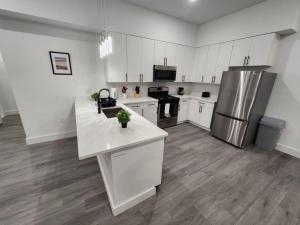a kitchen with white cabinets and a stainless steel refrigerator at Vast Fully Furnished 2-Bed Close to NYC in Bayonne