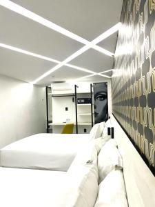1 dormitorio con 2 camas y pared en blanco y negro en The Andy Hotel en Querétaro