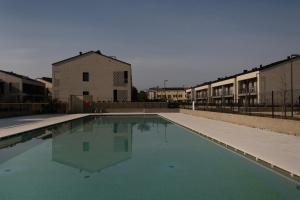 una piscina vuota di fronte a un edificio di residence borgo secolo a Peschiera del Garda