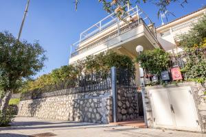 a building with a gate and a stone wall at Brisa Home Beach in Mazzeo