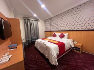 a hotel room with a bed and a flat screen tv at فندق رفاق Refaq Hotel in Makkah
