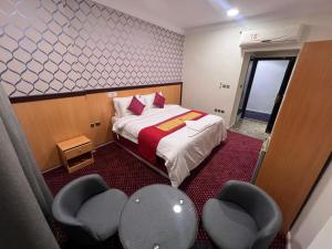 a small room with a bed and two chairs at فندق رفاق Refaq Hotel in Makkah