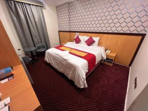 a hotel room with a bed with red and white sheets at فندق رفاق Refaq Hotel in Makkah