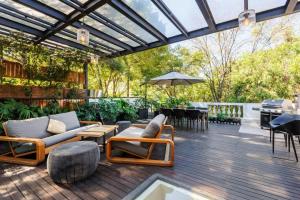 un patio con sillas, mesas y una sombrilla en Amazing Casa Wynwood in Roma Norte en Ciudad de México