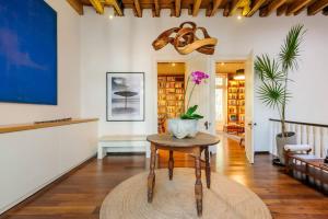 una sala de estar con una mesa con un jarrón. en Amazing Casa Wynwood in Roma Norte en Ciudad de México