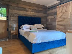 een blauw bed in een slaapkamer met een houten muur bij Little Mount, Rye in Rye