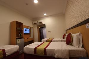 a hotel room with two beds and a television at فندق رفاق Refaq Hotel in Makkah