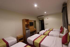 a hotel room with four beds in a room at فندق رفاق Refaq Hotel in Makkah