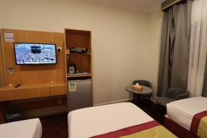a small room with two beds and a tv at فندق رفاق Refaq Hotel in Makkah