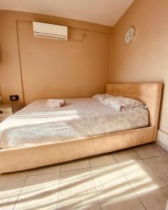 a bed in a bedroom with a clock on the wall at Elegant Studio in the center of city. in Thessaloniki