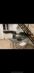 eine kleine Küche mit einem Tisch und einer Treppe in der Unterkunft Maison cosy au coeur du vignoble d'Hautvillers in Hautvillers