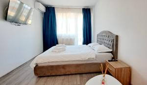 a bedroom with a bed and a window with blue curtains at Relax Home Apartment Q in Iaşi