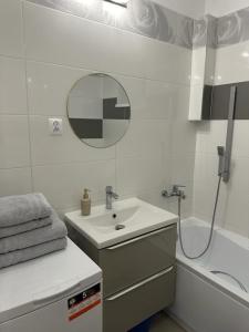 een badkamer met een wastafel, een spiegel en een bad bij Apartament Zasanie 2 Przemyśl in Przemyśl