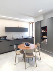 a kitchen with a table and chairs in a room at AL PONTE design apartment in Conegliano