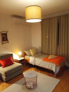a bedroom with two beds and a couch and a lamp at FARIS in Donji Milanovac